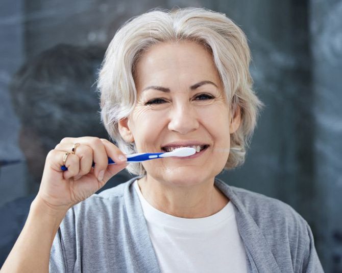 Senior woman brushing her teeth