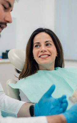 Woman with dentures smiling at the dentist