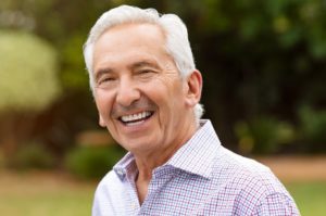 Senior man smiling after resolving dental emergency in Edison