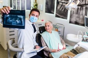 dentist showing patient an x-ray with dental implants during consultation