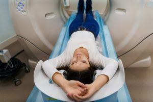 Woman with brown hair smiling during her MRI