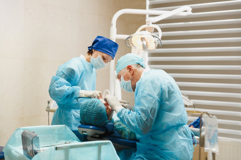 Dentists removing a failed dental implant in Edison