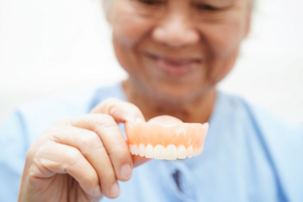 A man holding a denture